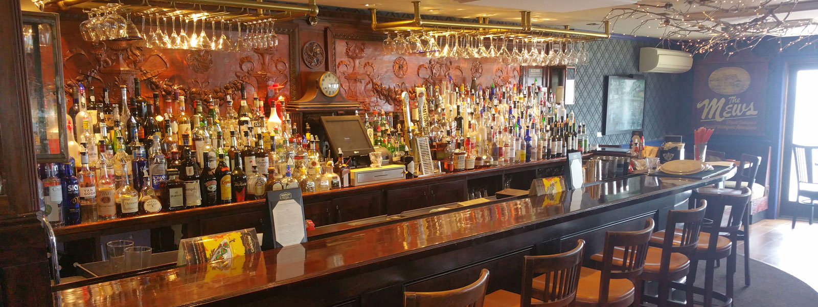 The hand-carved antique wood panels behind the main bar at The Mews.